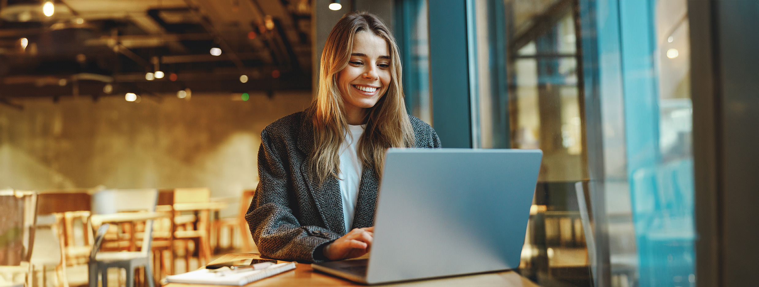 Kvinde sidder ved et kontorfællesskab med en computer